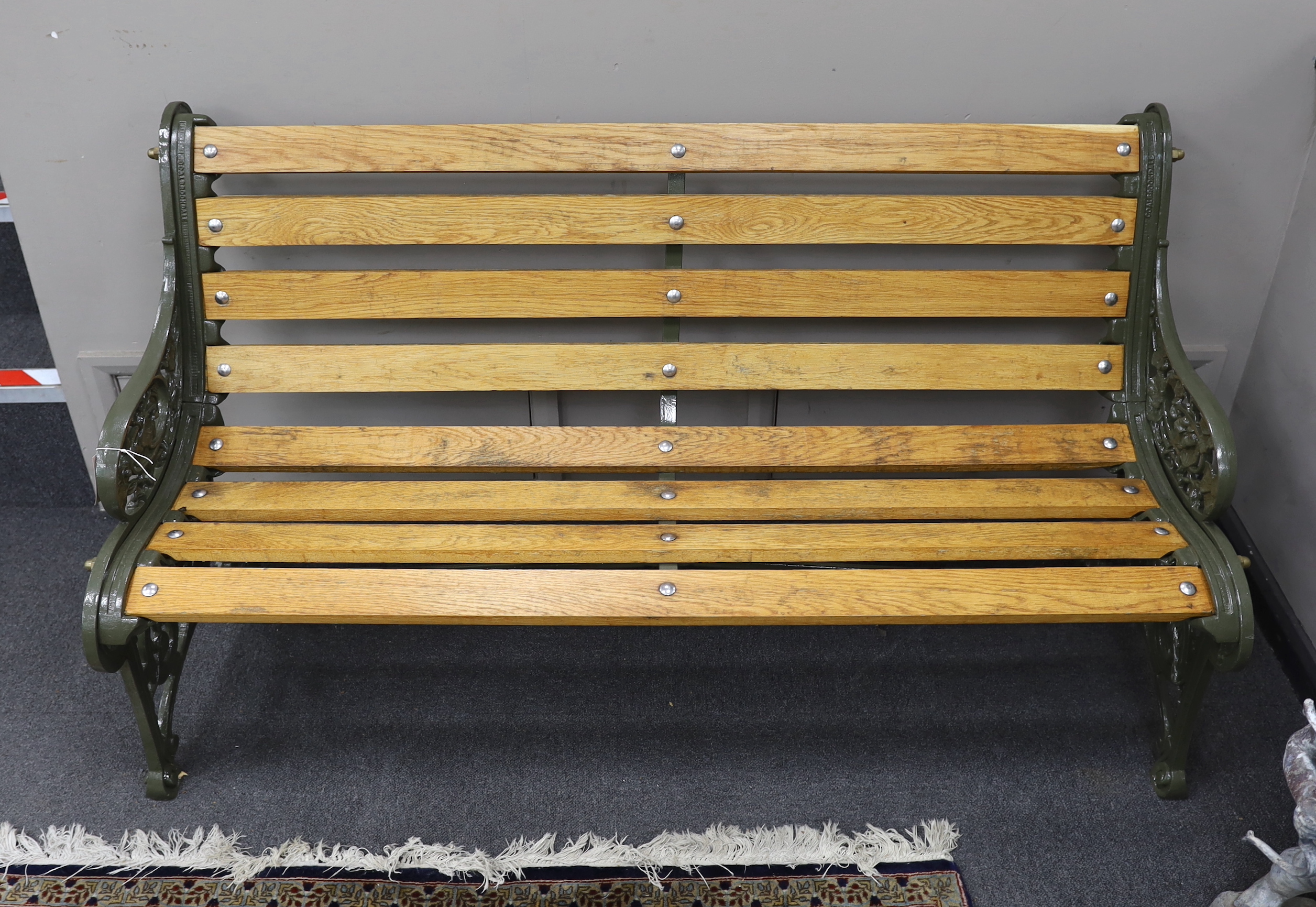 A Victorian Coalbrookdale 'nasturtium' pattern cast iron garden bench restored with later oak slats, length 146cm, depth 64cm, height 81cm